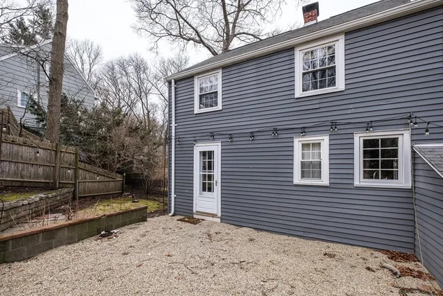 a view of a house with a yard and large tree