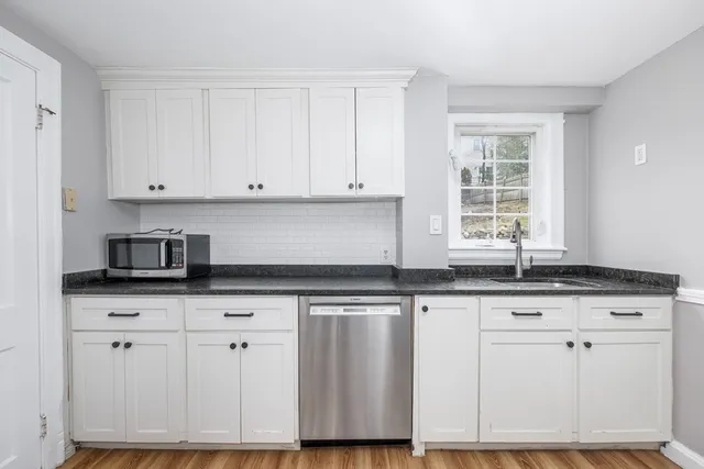 a kitchen with granite countertop a sink cabinets and window