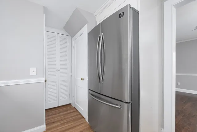 a view of a refrigerator in kitchen and white cabinets