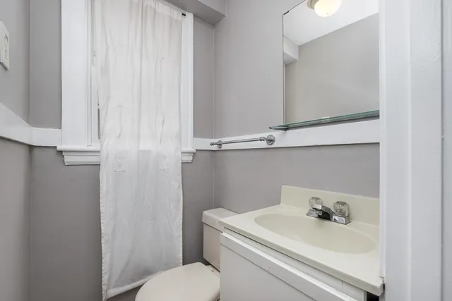 a bathroom with a sink a toilet and a mirror