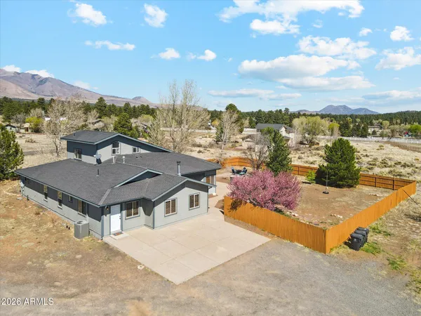a aerial view of a house with a swimming pool a yard and a mountain view