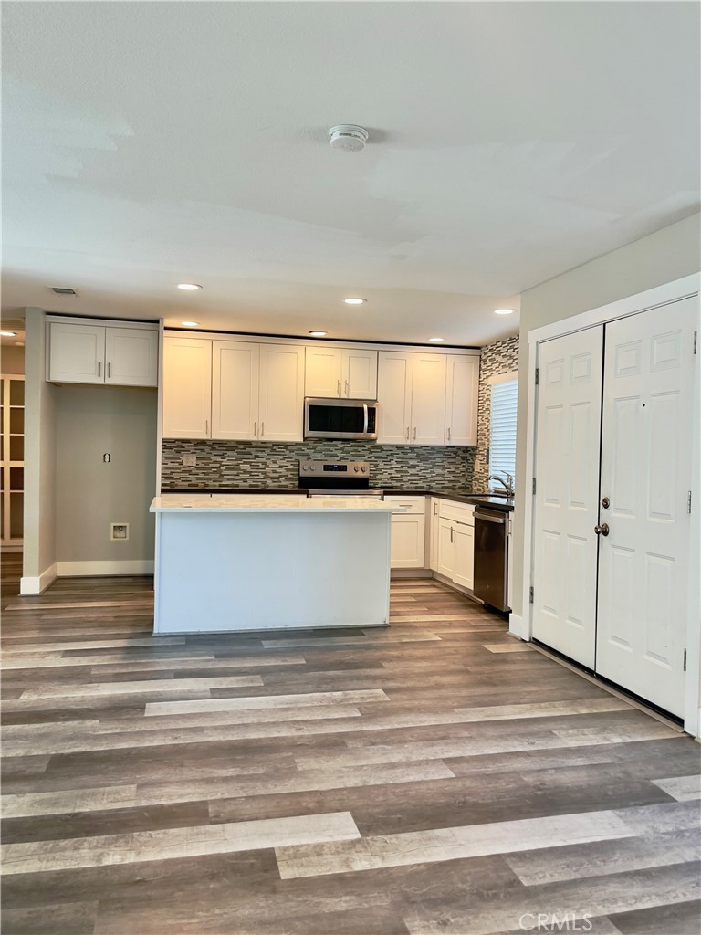 8317 Keyesport Way Citrus Heights, CA 95610 - Photo 5 of 28 a large kitchen with granite countertop a stove top oven a sink and white cabinets