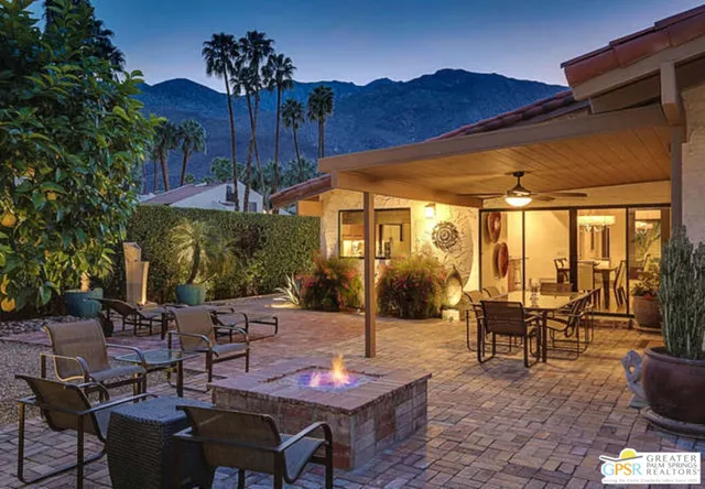 a view of a patio with table and chairs potted plants and palm tree