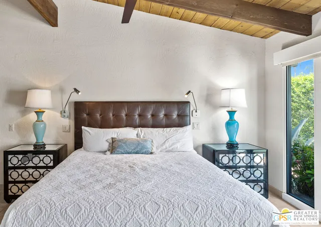 a bed sitting in a bedroom next to a window