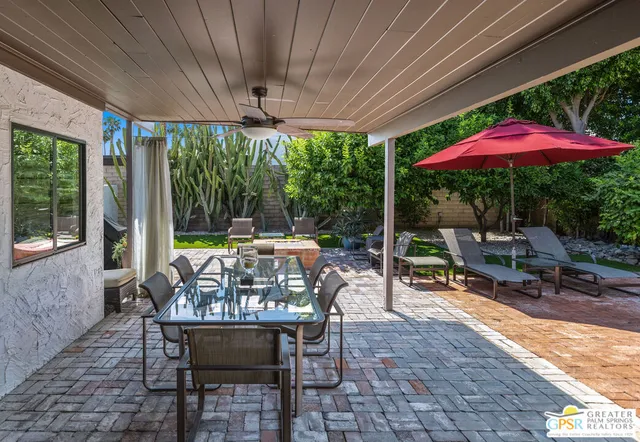 a view of a house with backyard and sitting area