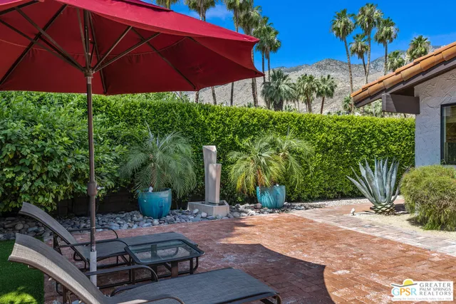 a view of a house with a yard and a palm tree