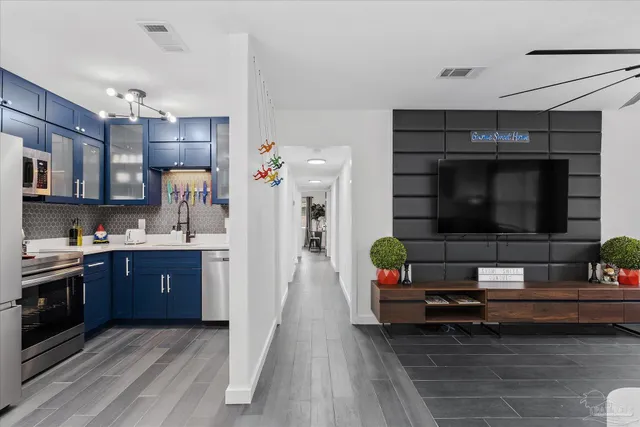 a living room with stainless steel appliances kitchen island granite countertop furniture and a view of kitchen