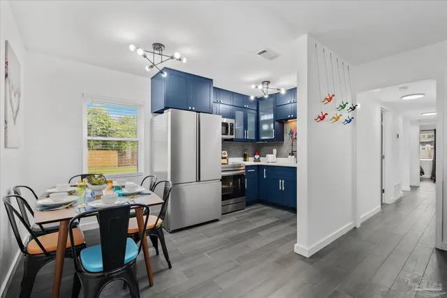 a kitchen with refrigerator a table and chairs in it