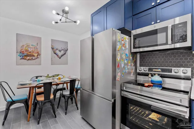 a kitchen with stainless steel appliances a refrigerator a stove a microwave and dining table