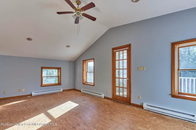 a view of a big room with windows and chandelier fan