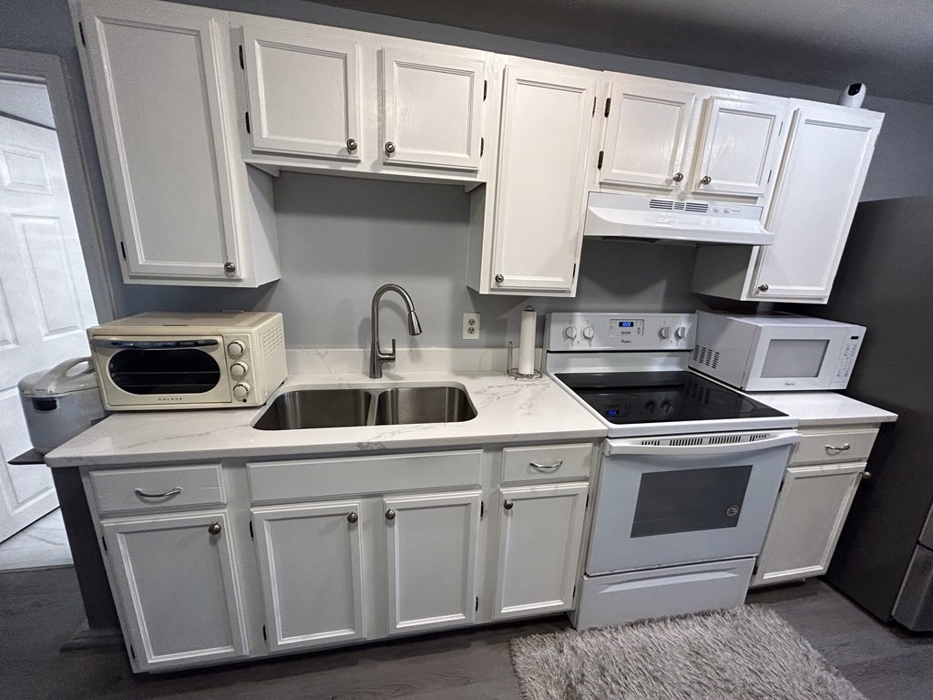 222 Gore Road Webster, MA 01570 - Photo 17 of 32 a kitchen with white cabinets and white appliances