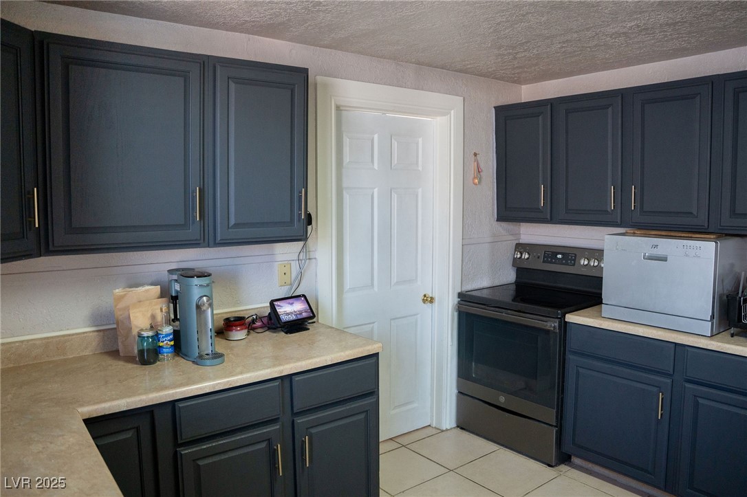 936 Ave G Ely, NV 89301 - Photo 5 of 20 Kitchen featuring electric range, light countertops, light tile patterned flooring