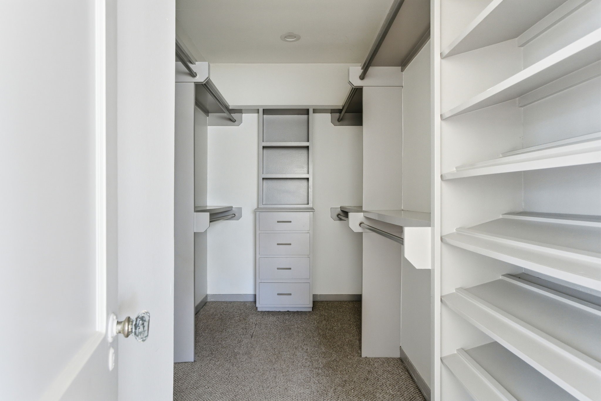 1103 Key Street Houston, TX 77009 - Photo 18 of 35 Spacious walk-in closet with ample shelving, hanging rods, and built-in drawers, ideal for organized storage. Carpeted floor adds comfort and warmth.
