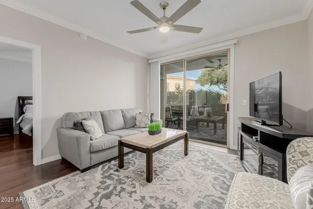 a living room with furniture a flat screen tv and a large window