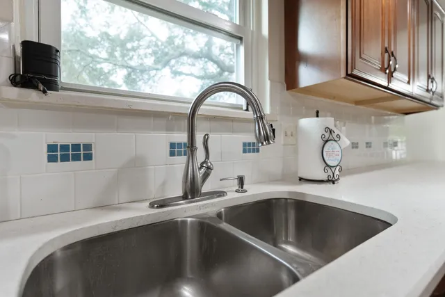 a kitchen with stainless steel appliances a sink dishwasher window and cabinets