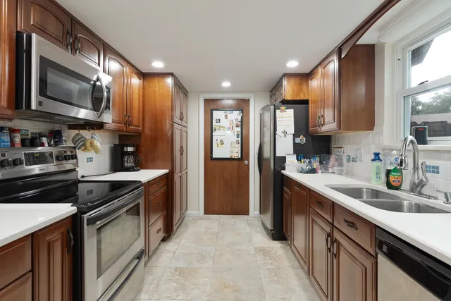 a kitchen with kitchen island sink stove and refrigerator