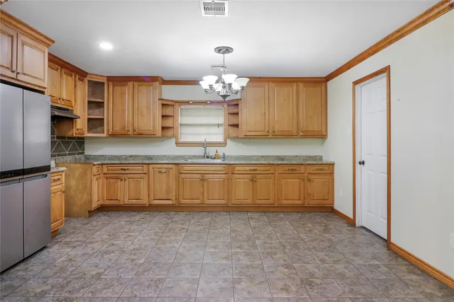 a kitchen with kitchen island granite countertop a stove sink and cabinets