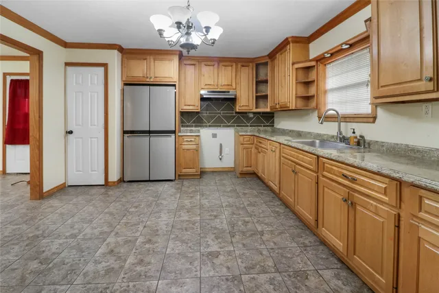 a kitchen with stainless steel appliances granite countertop a refrigerator a sink dishwasher a oven with white cabinets and wooden floor