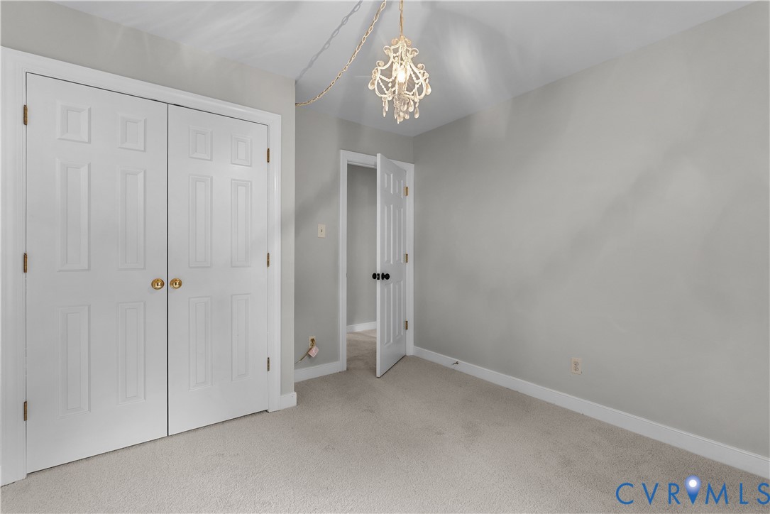14308 Chimney House Road Midlothian, VA 23112 - Photo 38 of 52 Neutral-toned room featuring a decorative chandeli