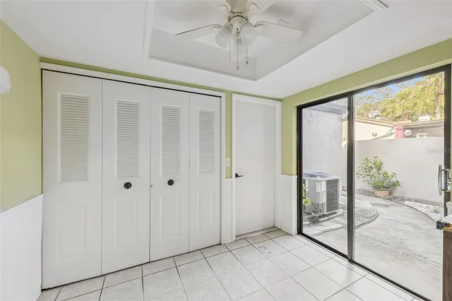 a view of a hallway with a chandelier fan and windows