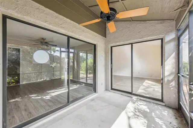 a view of a hallway with a ceiling fan and window