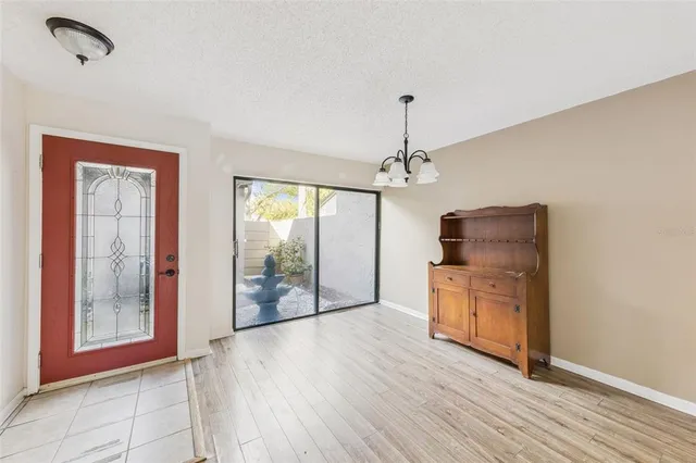 a view of a room with wooden floor cabinet and a view of kitchen