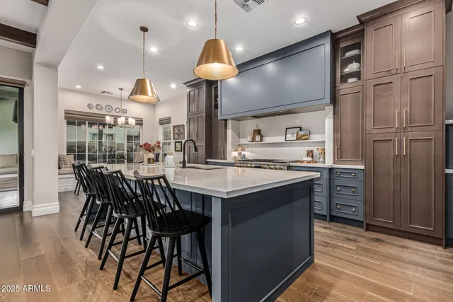 a kitchen with stainless steel appliances granite countertop a table chairs and a refrigerator