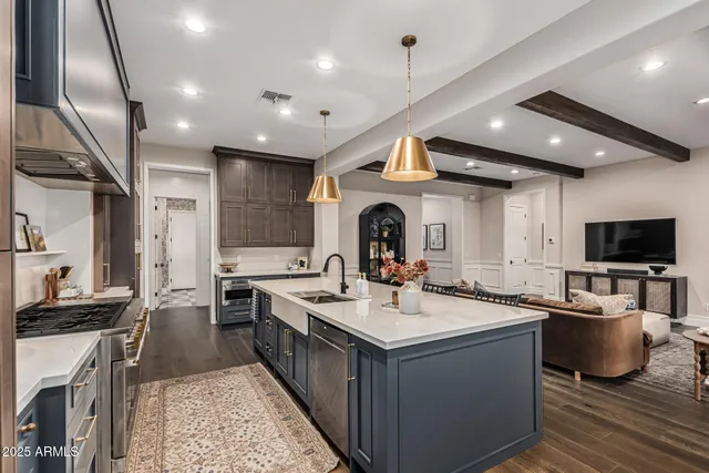 a large white kitchen with a large window and stainless steel appliances