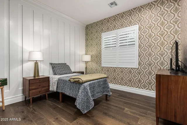 a bedroom with a bed and a lamp with wooden floor