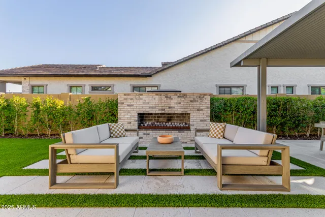 a view of swimming pool with lawn chairs and plants