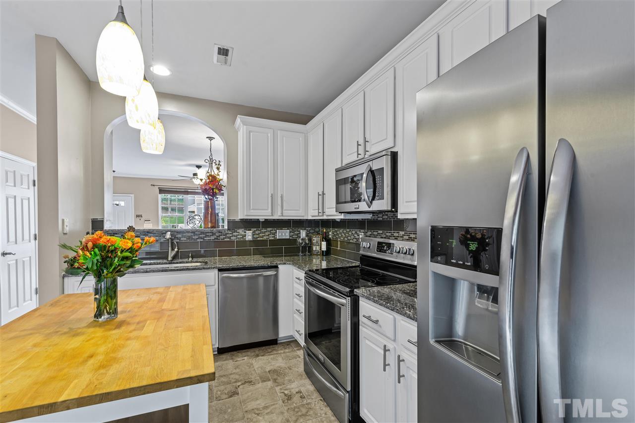 4822 Black Mountain Path Raleigh, NC 27612 - Photo 7 of 27 a kitchen with stainless steel appliances granite countertop a sink a stove and a refrigerator