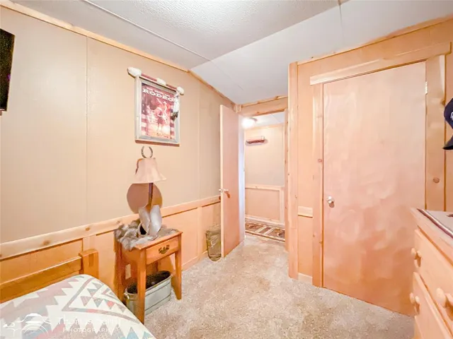 a bedroom with a bed and a lamp on dresser