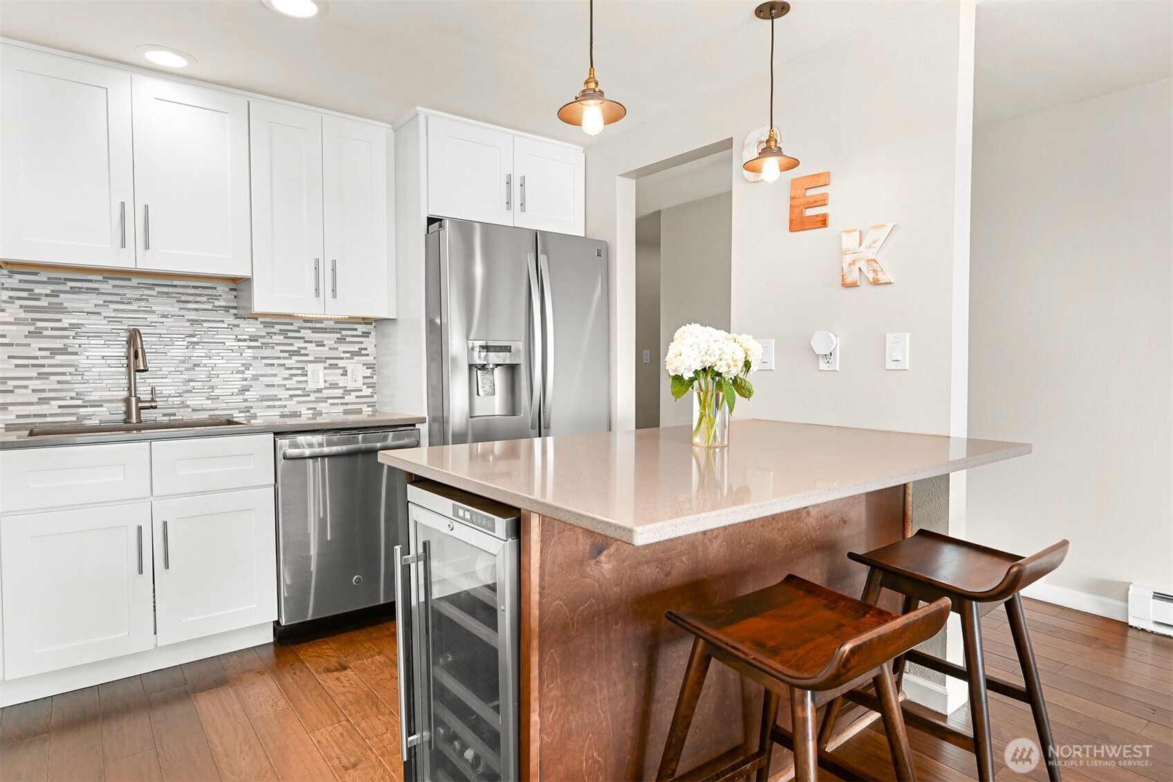 600 South State Street, Unit 212 Bellingham, WA 98225 - Photo 16 of 37 a kitchen with stainless steel appliances granite countertop a sink a refrigerator a stove a dining table and chairs with wooden floor
