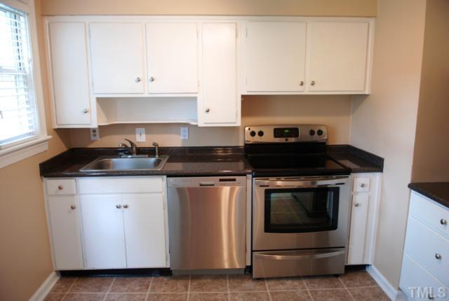917 St Marys Street Raleigh, NC 27605 - Photo 3 of 13 a kitchen with white cabinets and black appliances