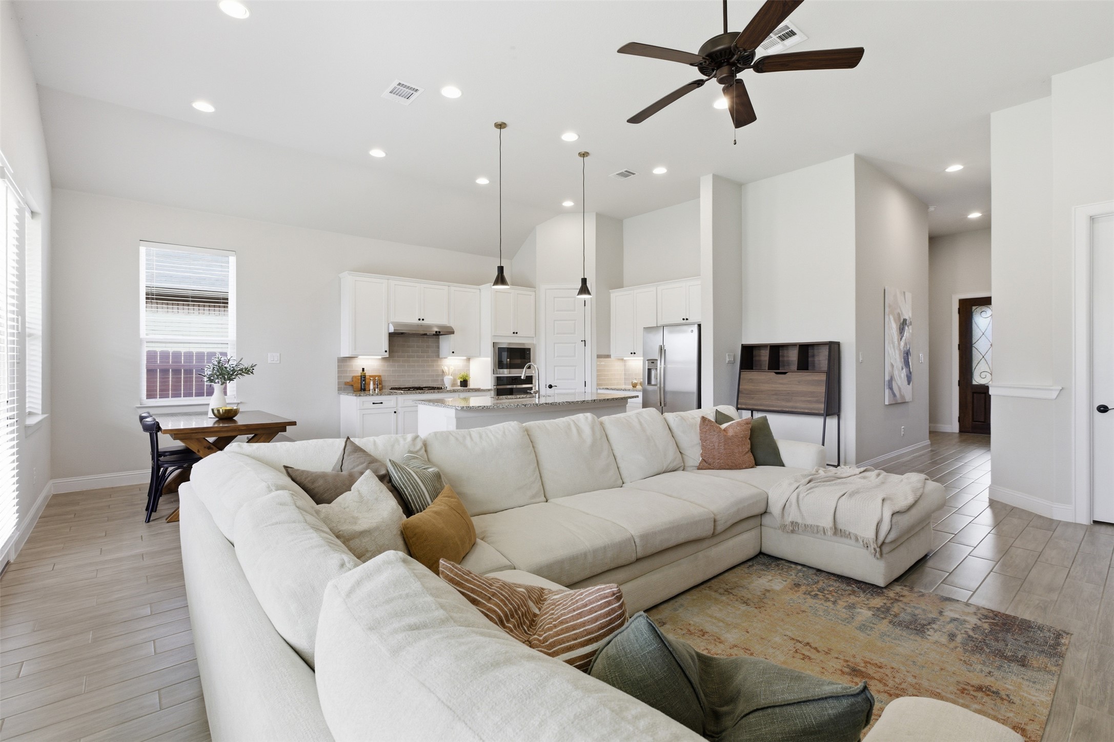 117 Old Trinity Way Georgetown, TX 78628 - Photo 12 of 38 Living room featuring wood tiled floors, a ceiling fan, recessed lighting, and a high ceiling