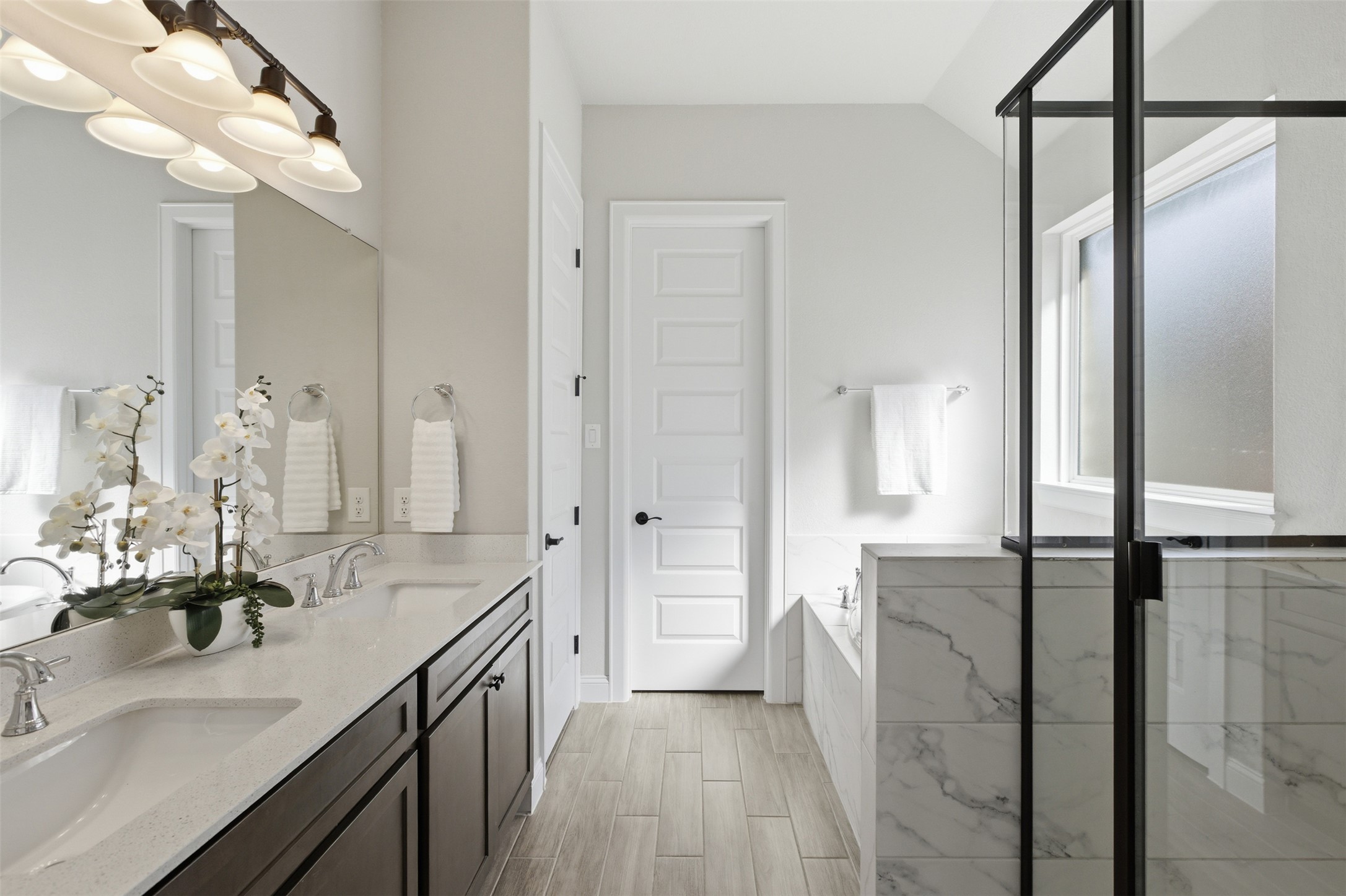 117 Old Trinity Way Georgetown, TX 78628 - Photo 21 of 38 Full bathroom featuring double vanity, a stall shower, wood tiled floors, a garden tub, and suspended lighting