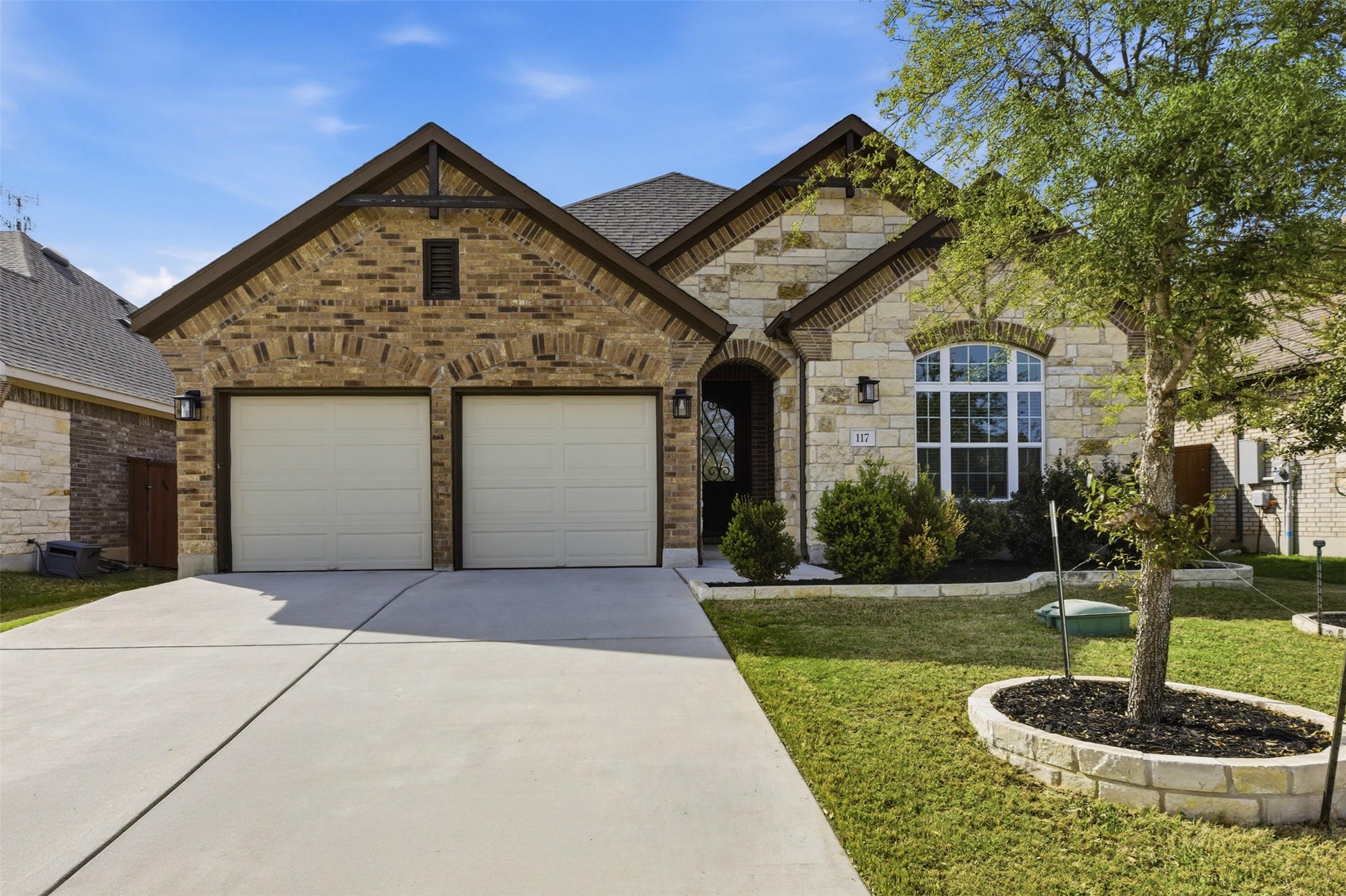117 Old Trinity Way Georgetown, TX 78628 - Photo 3 of 38 French country inspired facade featuring driveway, stone siding, an attached garage, a front lawn, and brick siding