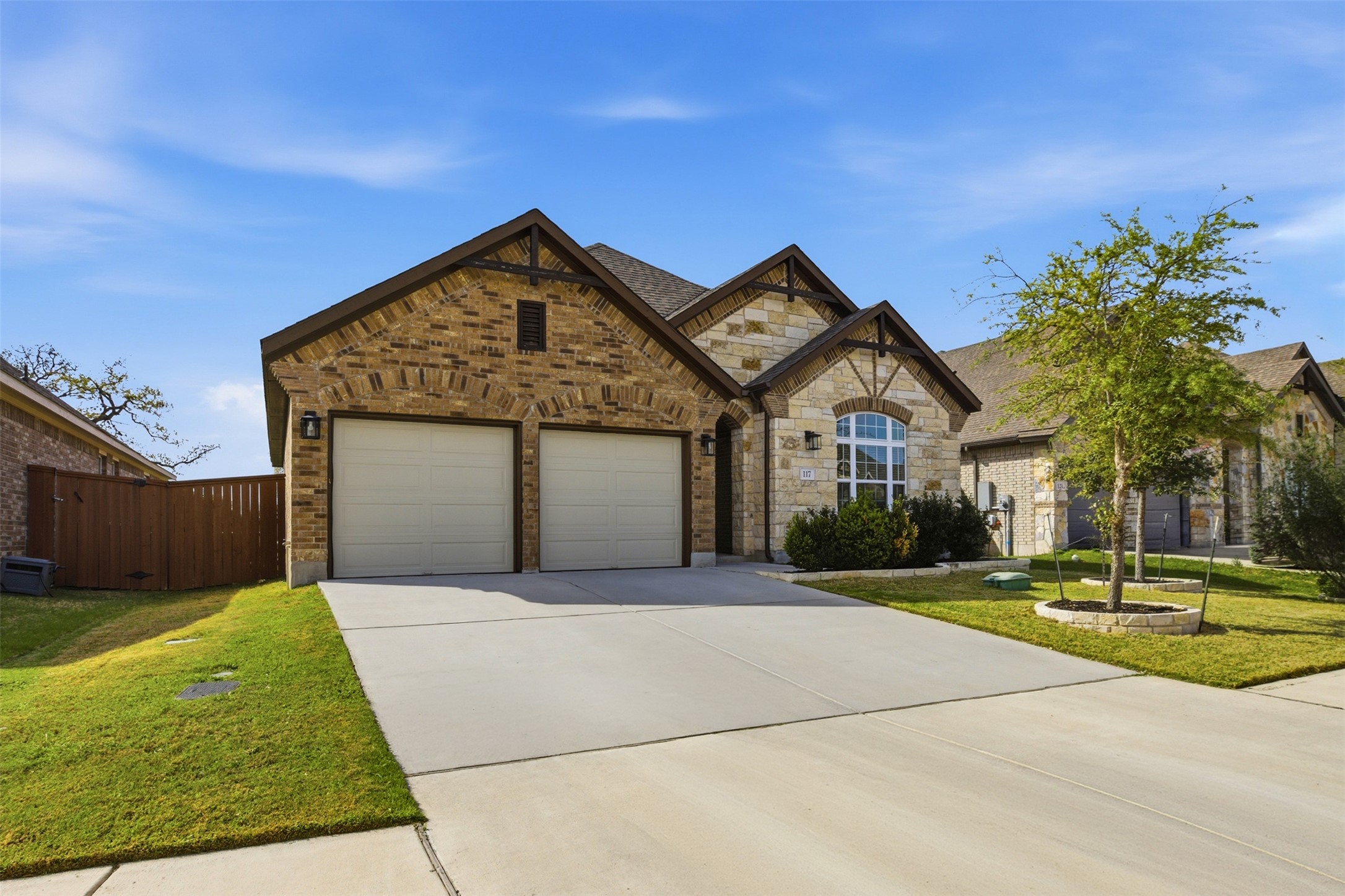 117 Old Trinity Way Georgetown, TX 78628 - Photo 5 of 38 View of front of home with driveway, a front lawn, an attached garage, brick siding, and stone siding