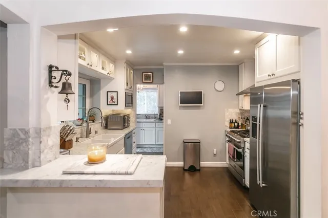 a kitchen with stainless steel appliances granite countertop a refrigerator and a sink
