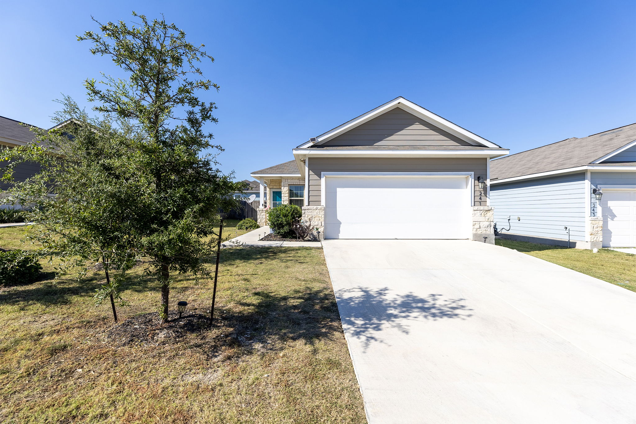 241 El Dorado Road Jarrell, TX 76537 - Photo 1 of 1 View of front of property featuring driveway, a front lawn, and a garage
