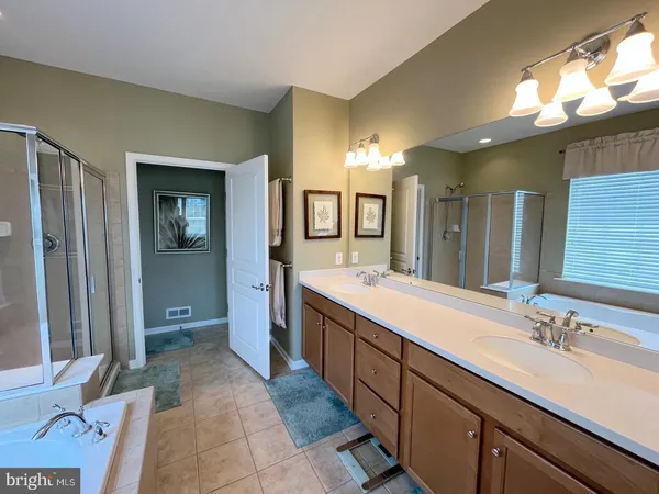 a spacious bathroom with a double vanity sink and a mirror