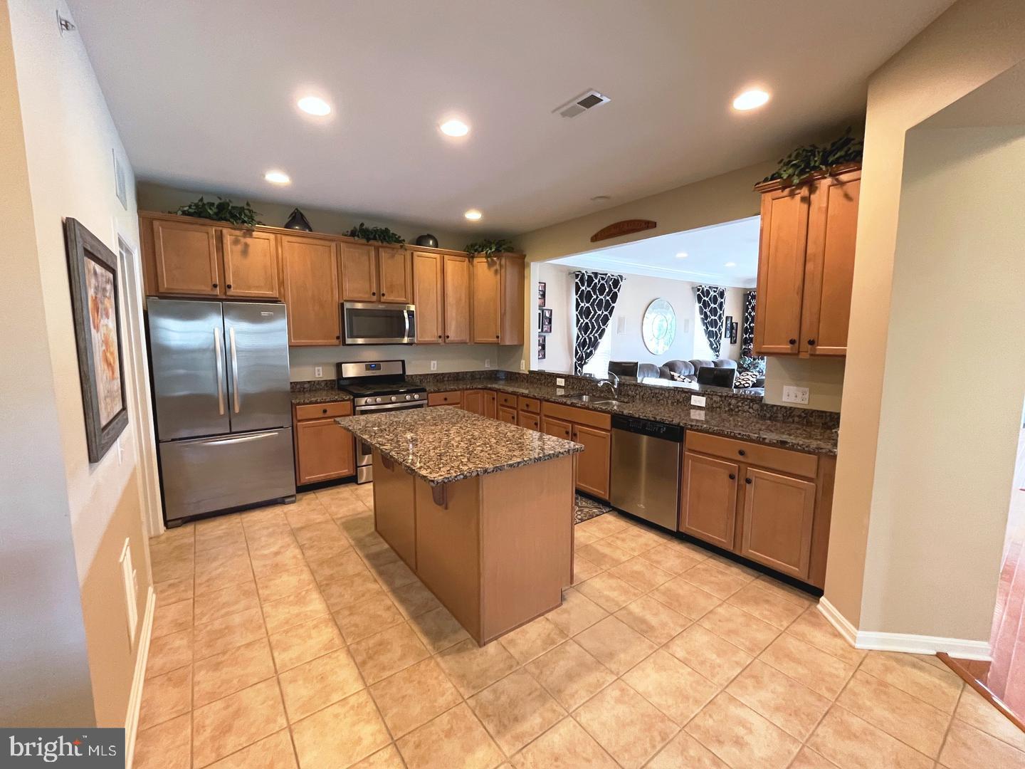 615 Prizer Court Downingtown, PA 19335 - Photo 6 of 35 a kitchen with stainless steel appliances granite countertop a stove a sink and a refrigerator