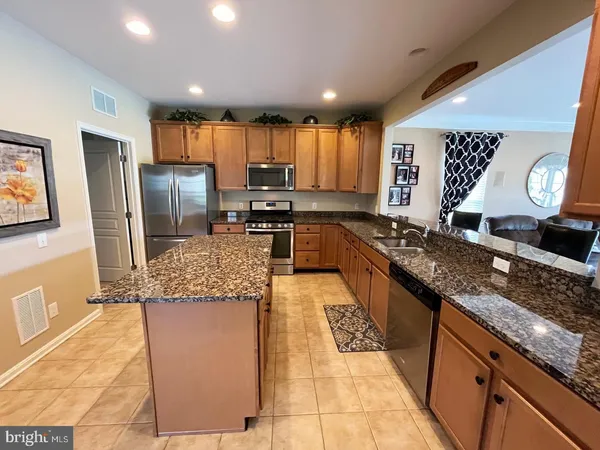 a large kitchen with kitchen island granite countertop a large counter top and appliances