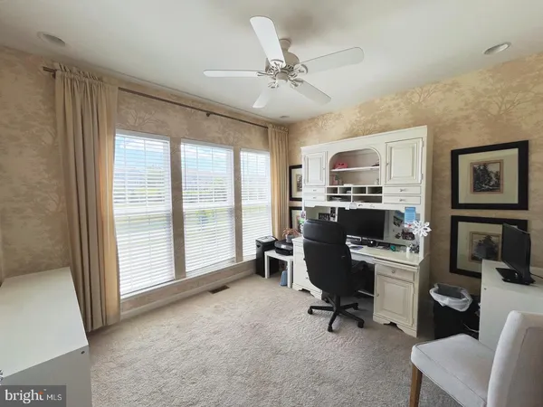 a view of a workspace with furniture and a window