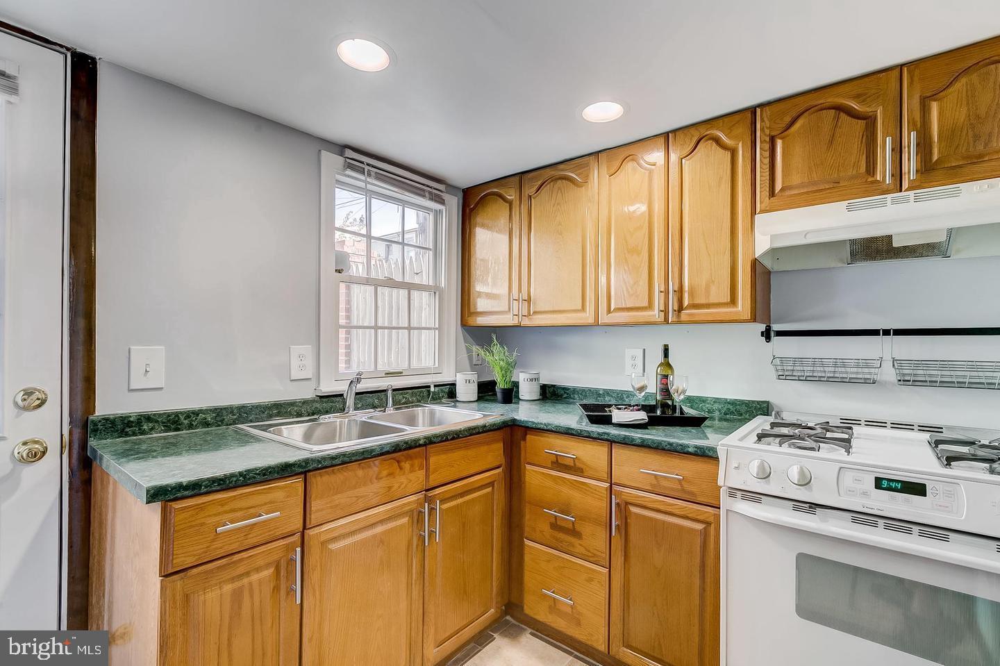 232 East Barney Street Baltimore, MD 21230 - Photo 12 of 23 a kitchen with granite countertop cabinets sink stove and refrigerator