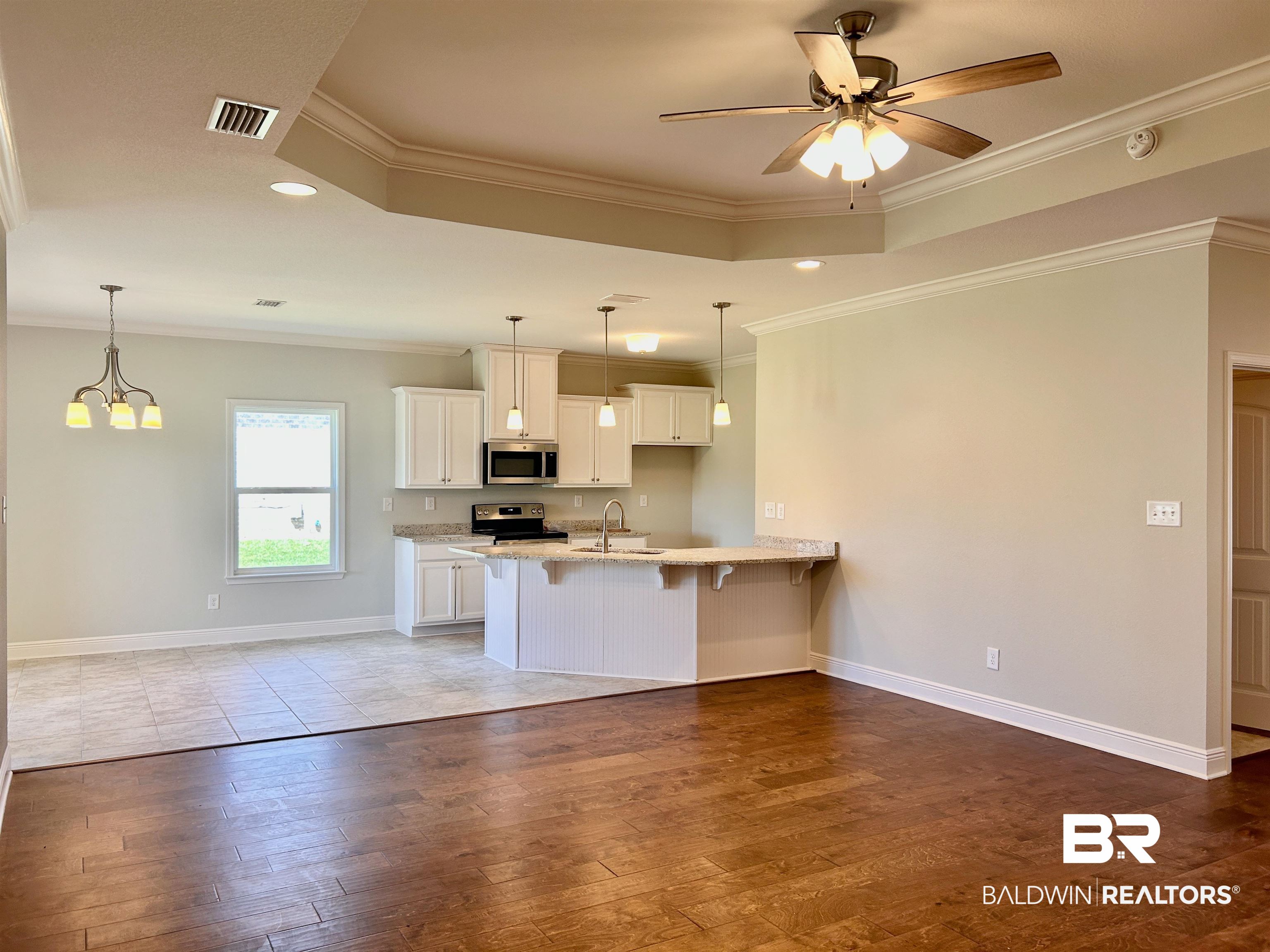 1267 Pembroke Way Foley, AL 36535 - Photo 5 of 17 Kitchen featuring stainless steel appliances, ceiling fan with notable chandelier, light wood-type flooring, and white cabinets