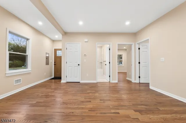 a view of empty room with wooden floor and windows