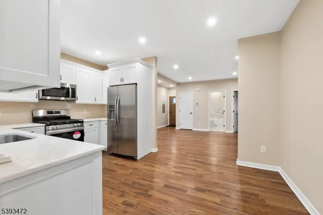 a kitchen with stainless steel appliances a refrigerator and a stove top oven