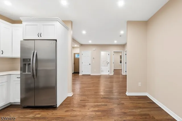 a view of a kitchen with a refrigerator and wooden floor