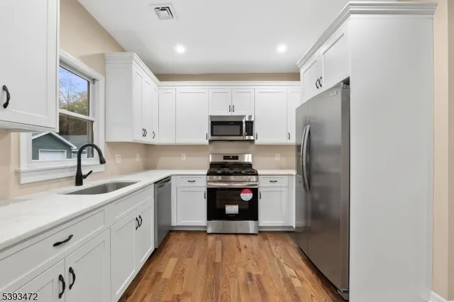 a kitchen with stainless steel appliances granite countertop a stove a sink and a refrigerator